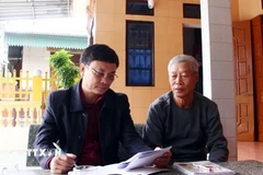 Cán bộ Ban công tác mặt trận khu dân cư Tân Cảnh (xã Hòa Trạch, Quảng Trị) tuyên truyền Luật bầu cử đến các ngư dân địa phương. (Ảnh: TTXVN phát)