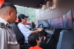 Người dân trải nghiệm xử lý tình huống lái xe ôtô thực tế ảo. (Ảnh: Hoàng Hiếu/TTXVN)