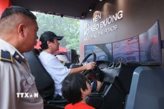Người dân trải nghiệm xử lý tình huống lái xe ôtô thực tế ảo. (Ảnh: Hoàng Hiếu/TTXVN)