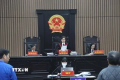 Chủ tọa phiên tòa công bố quyết định đưa vụ án ra xét xử. (Ảnh: Kim Anh/TTXVN)
