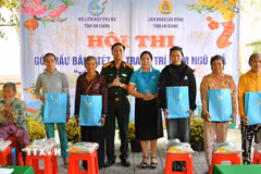 Đại tá Cao Minh Tâm, Phó Chính ủy Bộ Chỉ huy quân sự tỉnh và Phó Chủ tịch Hội Liên hiệp phụ nữ tỉnh An Giang Lê Thị Ngọc Dung trao quà cho người dân khó khăn xã Hòa Điền dịp tết Quân - Dân 2026. (Ảnh: Văn Sĩ/TTXVN)