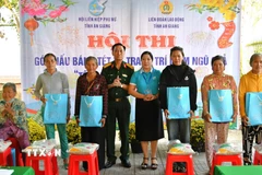 Đại tá Cao Minh Tâm, Phó Chính ủy Bộ Chỉ huy quân sự tỉnh và Phó Chủ tịch Hội Liên hiệp phụ nữ tỉnh An Giang Lê Thị Ngọc Dung trao quà cho người dân khó khăn xã Hòa Điền dịp tết Quân - Dân 2026. (Ảnh: Văn Sĩ/TTXVN)