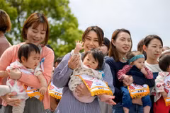 Các bậc phụ huynh bế con trước cuộc thi Nakisumo (hay còn gọi là cuộc thi Sumo dọa em bé khóc) tại chùa Sensoji ở Tokyo ngày 26/4/2025. (Ảnh: AFP/Getty Images)