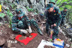 Trung tá Nguyễn Trung Kiên, Phó Chủ nhiệm Chính trị, Bộ Chỉ huy Quân sự tỉnh Hà Giang, trực tiếp chỉ đạo cất bốc 4 bộ hài cốt liệt sỹ vừa được tìm thấy tại khu vực Điểm cao 211. (Ảnh: TTXVN phát)