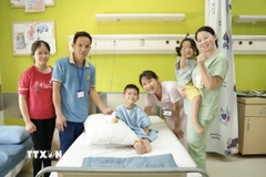 Niềm vui của gia đình bé Lê Duy Quang (11 tuổi, ngụ tỉnh Hà Tĩnh) sau phẫu thuật lần 1. (Ảnh: TTXVN phát)