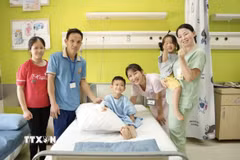 Niềm vui của gia đình bé Lê Duy Quang (11 tuổi, ngụ tỉnh Hà Tĩnh) sau phẫu thuật lần 1. (Ảnh: TTXVN phát)