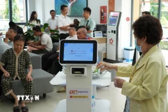 Người dân trải nghiệm các robot phục vụ. (Ảnh: Hữu Duyên/TTXVN)
