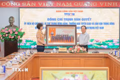 Đồng chí Vũ Việt Trang, Ủy viên Ban Thường vụ Đảng ủy các cơ quan Đảng Trung ương, Phó Trưởng Ban Tuyên giáo và Dân vận Trung ương, Bí thư Đảng ủy, Tổng Giám đốc Thông tấn xã Việt Nam trao ảnh lưu niệm tặng Trưởng Ban Tuyên giáo và Dân vận Trung ương Trịnh Văn Quyết. (Ảnh: Lê Đông/TTXVN)