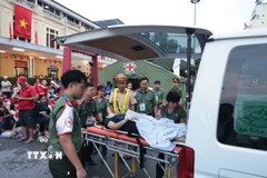 Lực lượng chức năng hỗ trợ chăm sóc sức khỏe một người dân bị ngất trên phố Lê Duẩn ngày 30/8. (Ảnh: Trần Việt/TTXVN)