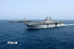 Tàu sân bay USS Abraham Lincoln (phía sau) của hải quân Mỹ di chuyển trên Biển Arab. (Ảnh: AP/TTXVN)