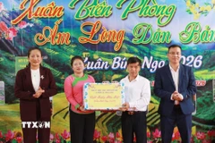 Lãnh đạo xã Khổng Lào trao quà Tết cho đại diện bản Nà Vàng. (Ảnh: Quý Trung/TTXVN)