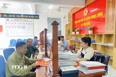 Người dân giải quyết thủ tục về đất đai tại Trung tâm phục vụ hành chính công xã Cẩm Hưng. (Ảnh: Hữu Quyết/TTXVN)