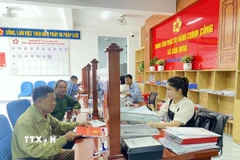 Người dân giải quyết thủ tục về đất đai tại Trung tâm phục vụ hành chính công xã Cẩm Hưng. (Ảnh: Hữu Quyết/TTXVN)