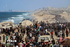 Người dân Palestine mang theo đồ đạc trở về thành phố Gaza ngày 10/10/2025. (Ảnh: THX/TTXVN)