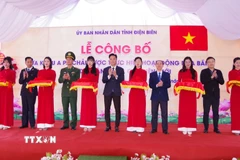 Các đại biểu thực hiện nghi thức cắt băng công bố Quyết định của UBND tỉnh Điện Biên về Cửa khẩu A Pa Chải. (Ảnh: TTXVN phát)