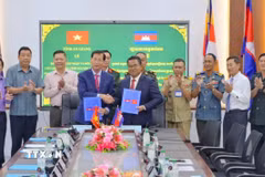 Ban chuyên trách 2 tỉnh ký kết biên bản bàn giao, tiếp nhận hài cốt liệt sỹ. (Ảnh: TTXVN phát)