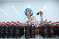 Nhân viên bộ phận QC kiểm tra ngoại quan chất lượng sản phẩm Trà thanh nhiệt Dr Thanh tại nhà máy của Tân Hiệp Phát. Các sản phẩm của Tân Hiệp Phát 9 năm liên tiếp đạt tiêu chuẩn Halal.
