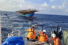 Lực lượng cứu nạn tiếp cận tàu cá bị nạn. (Ảnh: Báo Quảng Ngãi)