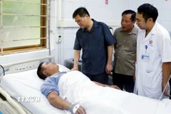 Ông Bùi Văn Khắng, Chủ tịch UBND tỉnh Quảng Ninh (áo xanh) thăm công nhân bị thương đang điều trị tại Bệnh viện Đa khoa tỉnh Quảng Ninh. (Ảnh: TTXVN phát)