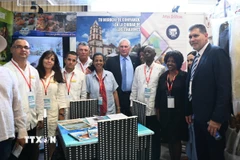 Chủ tịch Miguel Díaz-Canel Bermúdez (giữa) chụp ảnh tại một gian hàng ở Hội chợ. (Ảnh: Việt Hùng/TTXVN)
