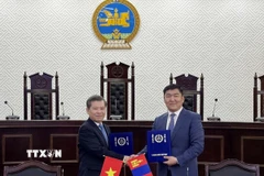 Chánh án Tòa án Nhân dân Tối cao Lê Minh Trí (trái) và Chánh án Tòa án Tối cao Mông Cổ Ganzorig Damdin trao đổi Bản ghi nhớ hợp tác giữa hai bên. (Ảnh: Công Tuyên/TTXVN)