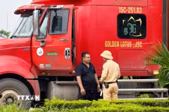 Cán bộ Đội Cảnh sát giao thông đường bộ số 15 (Phòng Cảnh sát giao thông Hà Nội) tuyên truyền, hướng dẫn lái xe chấp hành quy định về tải trọng và lộ trình lưu thông đối với phương tiện ra, vào khu công nghiệp Nguyên Khê. (Ảnh: Trung Nguyên/TTXVN)