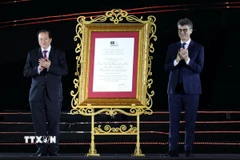 Ông Jonathan Baker, Trưởng Đại diện UNESCO tại Việt Nam (bên phải) trao Bằng UNESCO ghi danh Quần thể Di tích và Danh thắng Yên Tử - Vĩnh Nghiêm - Côn Sơn, Kiếp Bạc là Di sản văn hóa thế giới cho ông Tạ Quang Đông, Thứ trưởng Bộ Văn hóa, Thể thao và Du lịch. (Ảnh: Đức Hiếu/TTXVN)