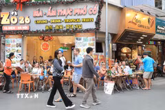 Khách du lịch nước ngoài thưởng thực ẩm thực tại phố Tạ Hiện, Hà Nội. (Ảnh: Hoàng Hiếu/TTXVN)