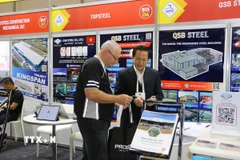 Khách tham quan Australia tìm hiểu về các sản phẩm trưng bày của Việt Nam tại Triển lãm. (Ảnh: Thanh Tú/TTXVN)