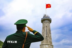 Chiến sỹ thực hiện nghi thức chào cờ tại Cột cờ A Pa Chải. (Ảnh: Xuân Tư/TTXVN)