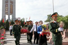 Nghi lễ an táng 76 hài cốt liệt sỹ quân tình nguyện và chuyên gia Việt Nam hi sinh tại Lào. (Ảnh: Văn Tý/TTXVN