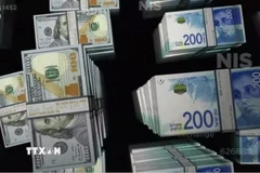 Đồng shekel (phải) của Israel và đồng đôla Mỹ. (Ảnh: Reuters/TTXVN)