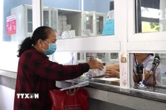 Bệnh nhân khám Bảo hiểm y tế nhận thuốc tại bệnh viện. (Ảnh: Minh Phú/TTXVN)