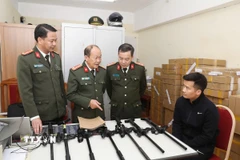 Đối tượng Vi Văn Duy (ngồi) cùng tang vật bị thu giữ. (Ảnh: TTXVN phát)