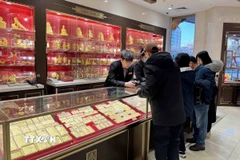 Người dân Trung Quốc mua sắm vàng dịp Tết nguyên đán 2025. (Ảnh: Công Tuyên/TTXVN)