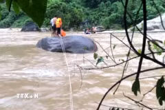 Chiến sỹ Đồn Biên phòng Pa Vệ Sử, Lai Châu, kịp thời cứu 3 người dân bị mắc kẹt giữa dòng nước lũ tại khu vực hồ thủy điện Nậm Sì Lường, xã Bum Nưa, tỉnh Lai Châu. (Ảnh: TTXVN phát)