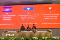 Bộ trưởng Quốc phòng Việt Nam-Lào-Campuchia ký biên bản cuộc gặp. (Ảnh: Xuân Tú/TTXVN)