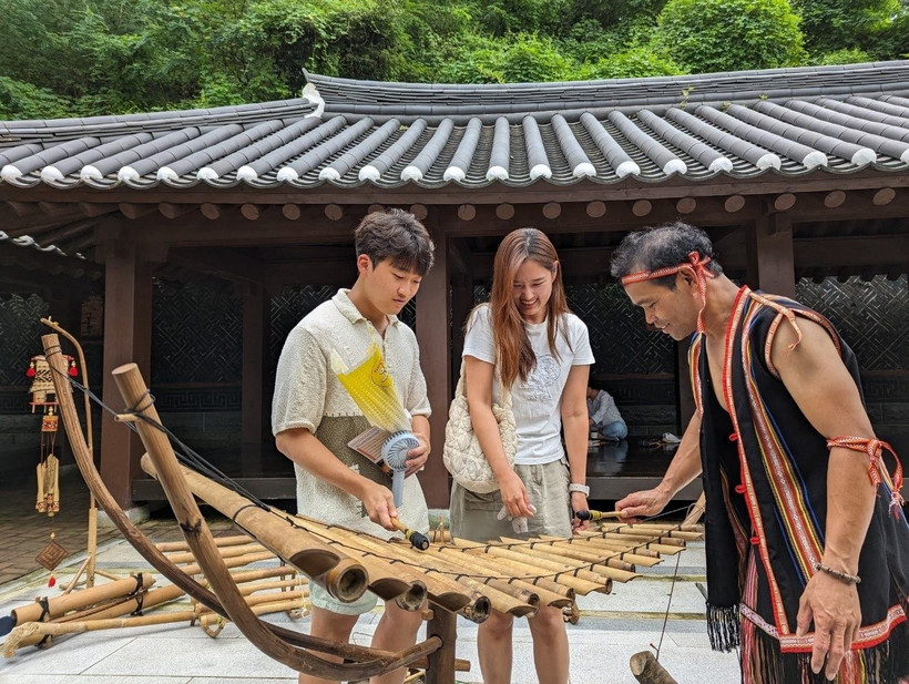Du khách Hàn Quốc trực tiếp trải nghiệm đàn T'Rưng, nhạc cụ dân tộc của vùng đất Tây Nguyên, Việt Nam. (Nguồn ảnh: Tarzan Tây Nguyên)