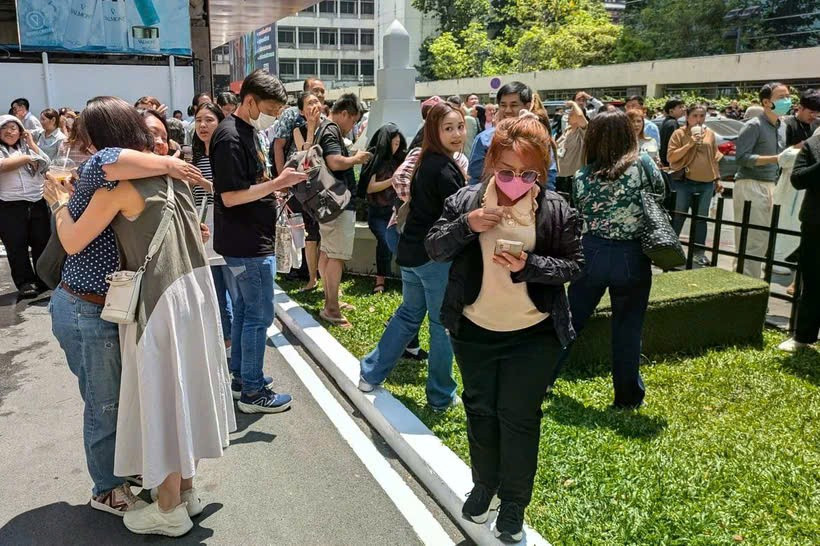 Người dân đứng bên ngoài một tòa nhà văn phòng ở Bangkok sau trận động đất. (Nguồn: AFP)