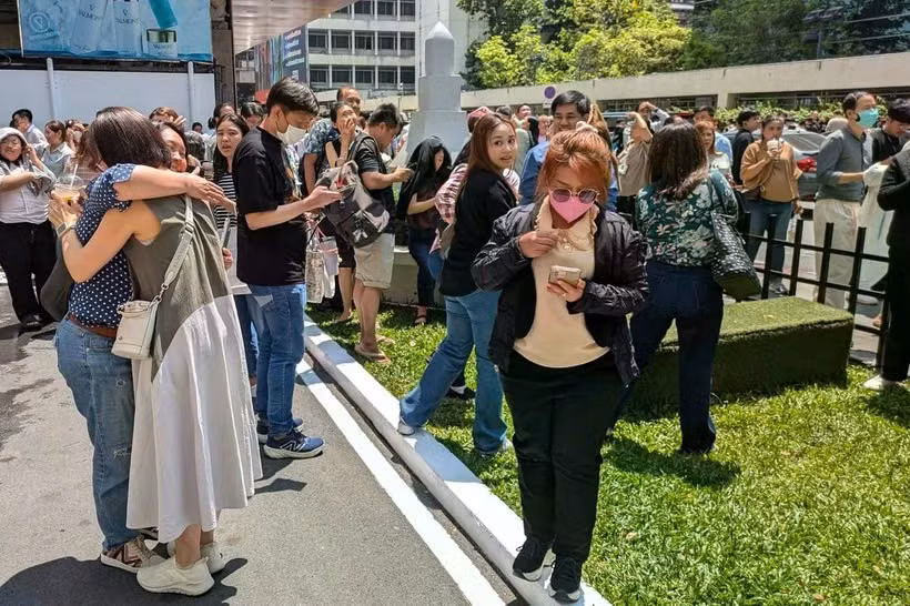 Người dân đứng bên ngoài một tòa nhà văn phòng ở Bangkok sau trận động đất. (Nguồn: AFP)