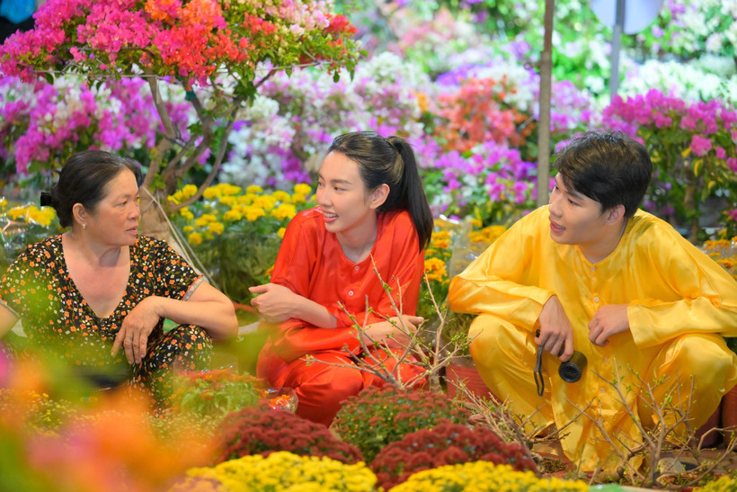 Hoa hậu Thùy Tiên và "anh trai" Quang Trung trải nghiệm bán hoa Tết bên bến sông Sài Gòn. (Ảnh: CTV/Vietnam+)