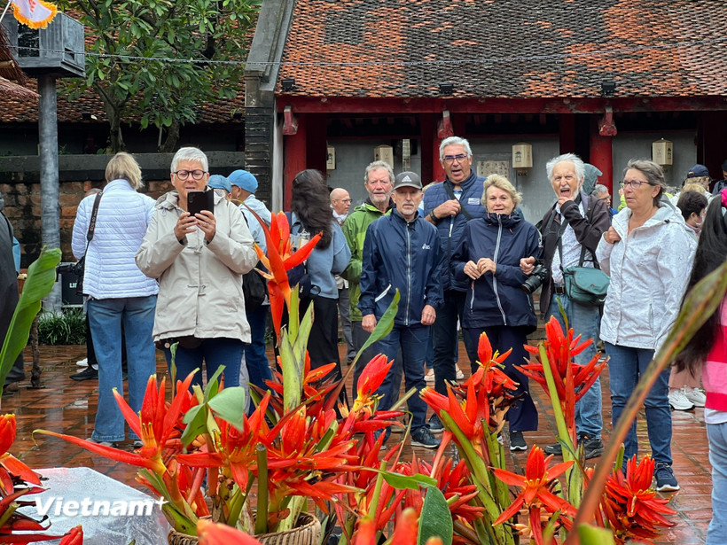 Du khách quốc tế thích thú khi được nghe giới thiệu về Văn Miếu-Quốc Tử Giám. (Ảnh: Mai Mai/Vietnam+)