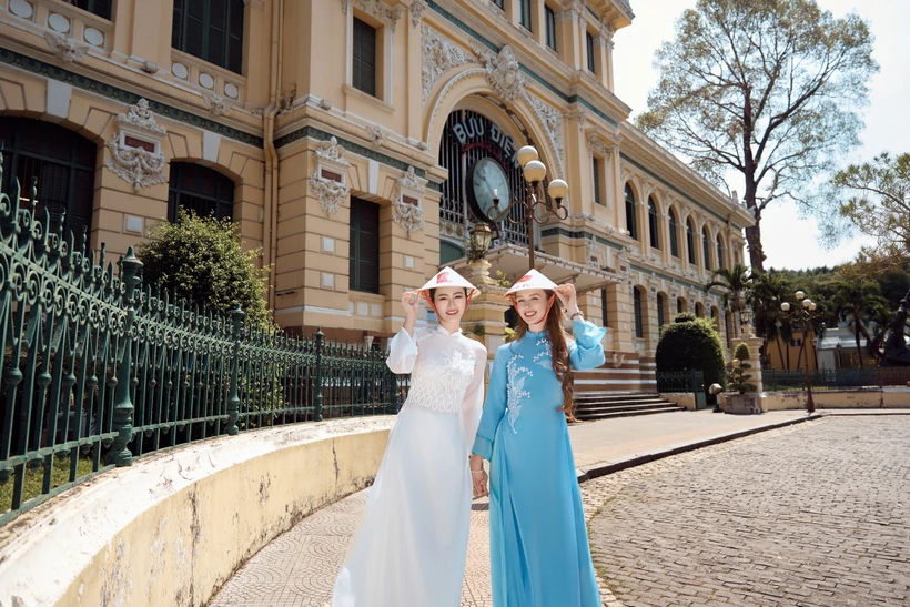 Miss World Scotland 2024 (áo dài xanh) khám phá những điểm đến biểu tượng của Sài Gòn. (Ảnh: CTV/Vietnam+)