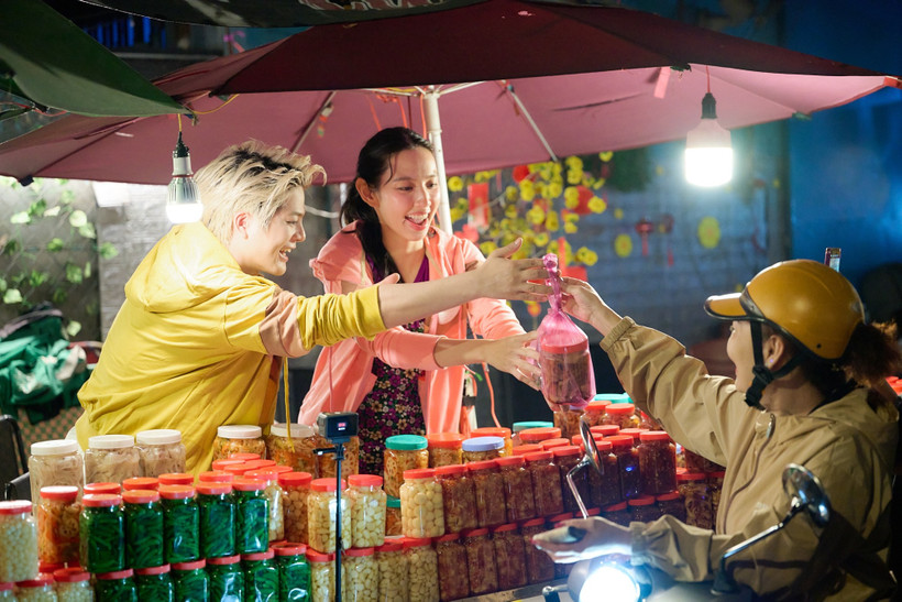 Hoa hậu Thùy Tiên và RHYDER đưa nhau đi bán củ kiệu trong “Đu Đêm.” (Ảnh: CTV/Vietnam+)