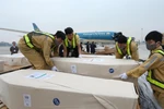 Nhân viên sân bay quốc tế Nội Bài vận chuyển thi thể các nạn nhân lên ôtô để đưa về quê nhà. (Ảnh: Lâm Khánh/TTXVN)