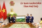 Lãnh đạo Ủy ban MTTQ Việt Nam tỉnh Phú Thọ tặng ảnh lưu niệm “Đồi chè Long Cốc” cho đại diện lãnh đạo Ủy ban Nhà nước về người Việt Nam ở nước ngoài. (Ảnh: Trung Kiên/TTXVN)