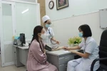 Bác sỹ của Phòng khám hậu COVID-19, Bệnh viện Đa khoa tỉnh Khánh Hòa thăm khám cho bệnh nhân đến khám do nghi ngờ mắc các triệu chứng hậu COVID-19. (Ảnh: Phan Sáu/TTXVN)