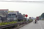 Lưu lượng xe đông, đường xuống cấp và hệ thống đường gom, cầu vượt chưa được thiết kế đầy đủ là những nguy hiểm rình rập với người đi trên Quốc lộ 5. (Ảnh: Huy Hùng/Vietnam+)