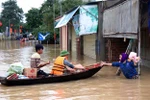 Lực lượng cứu trợ và các nhà hảo tâm vận chuyển hàng tới cho nhân dân vùng lũ. (Ảnh: Công Tường/TTXVN)