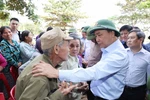 Thủ tướng Nguyễn Xuân Phúc thăm hỏi, chia sẻ khó khăn, mất mát với nhân dân thôn Đồng Tư, xã Hiền Ninh, huyện Quảng Ninh, tỉnh Quảng Bình. (Ảnh: Thống Nhất/TTXVN)